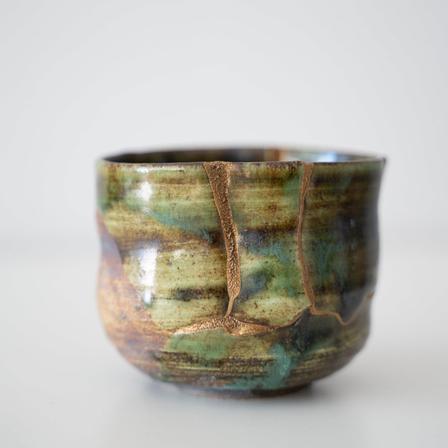 Close-up of Kintsugi Tea Bowl "Deep Forest Oribe" side, highlighting the intricate Kintsugi repairs