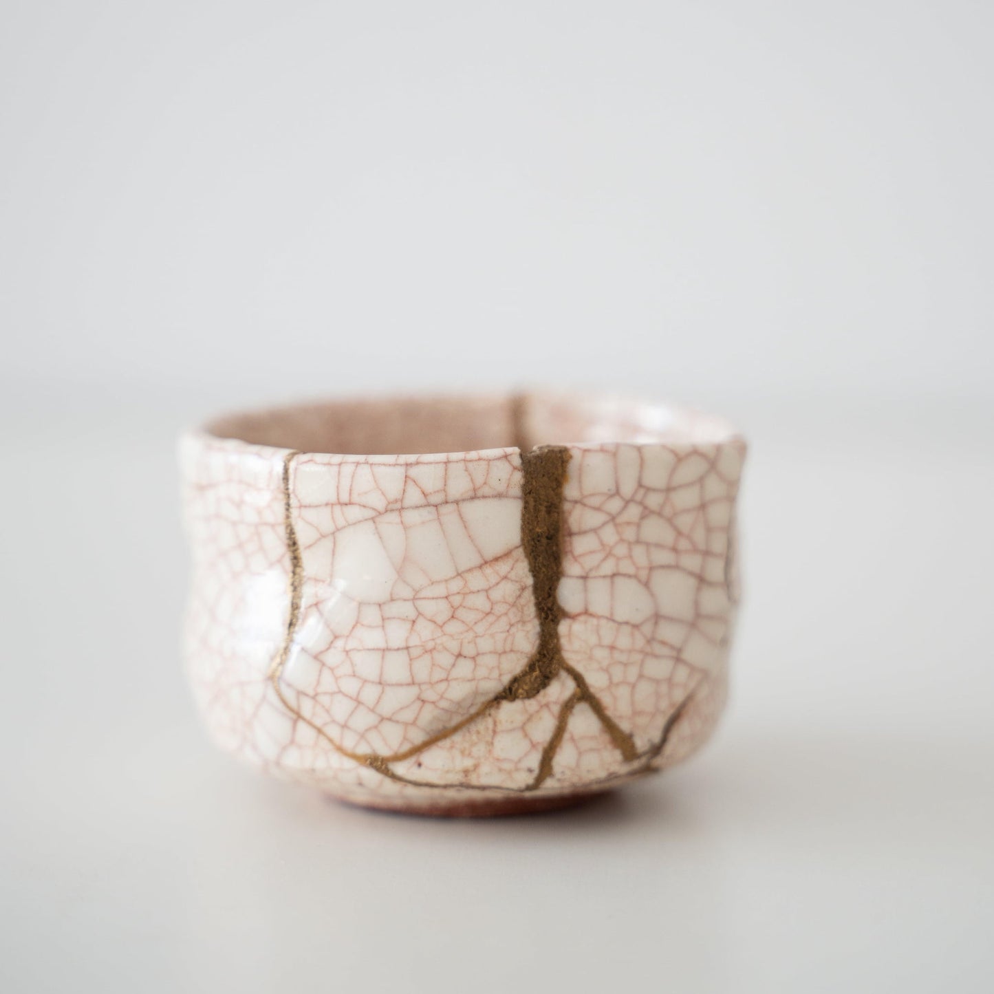 Close-up of Kintsugi Tea Bowl "Vermilion Crackle" side, highlighting the intricate Kintsugi repairs