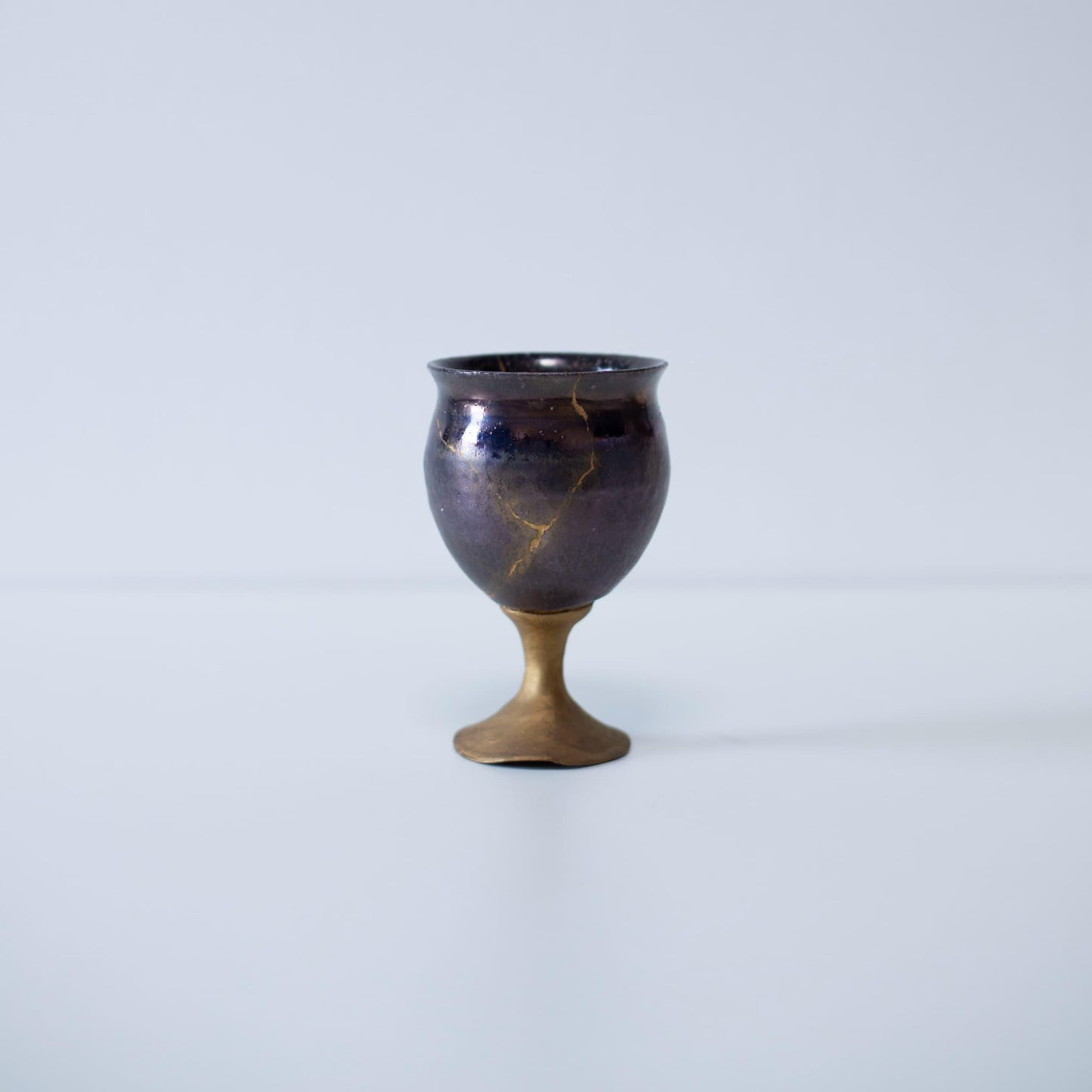 Magenta kintsugi wine goblet repaired with Kintsugi, a traditional Japanese technique.