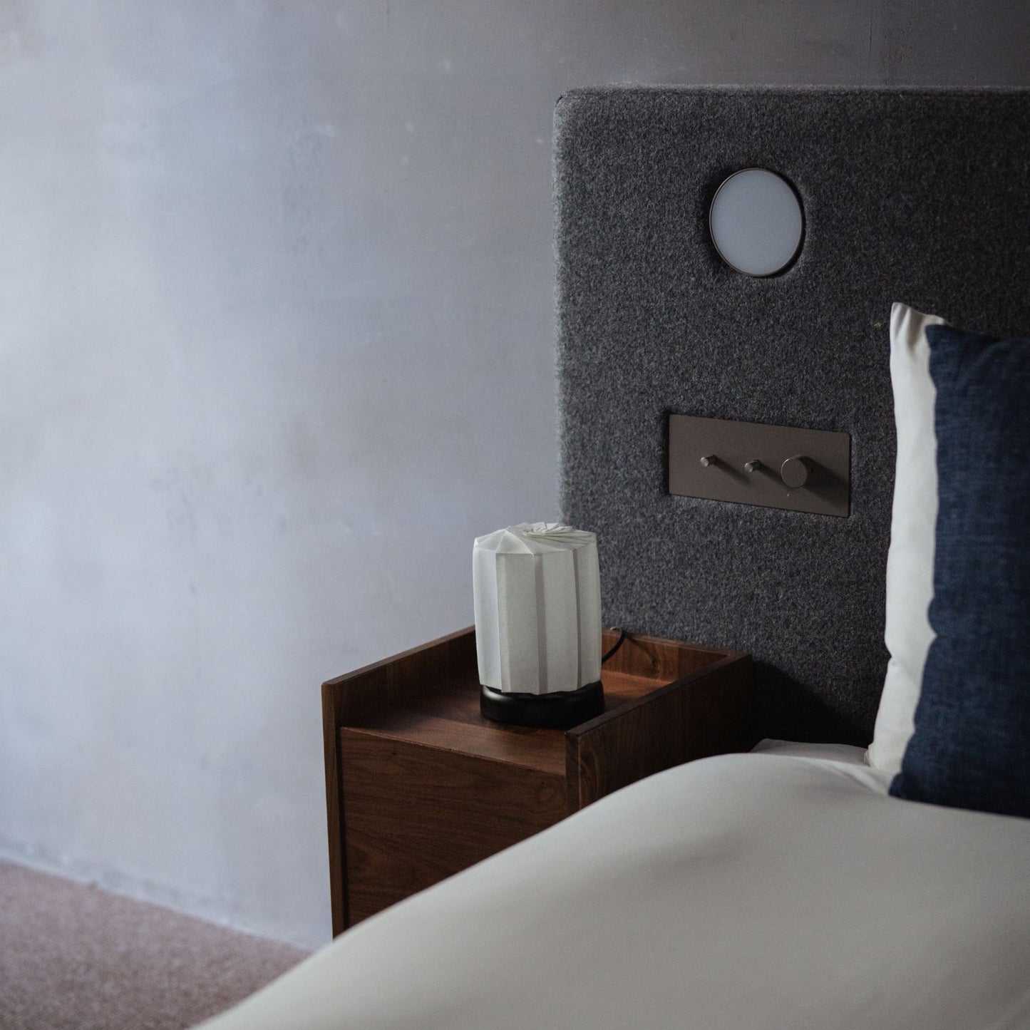 Japanese Paper Table Lamp "Flower of Light tutu M" on a wooden bedside table