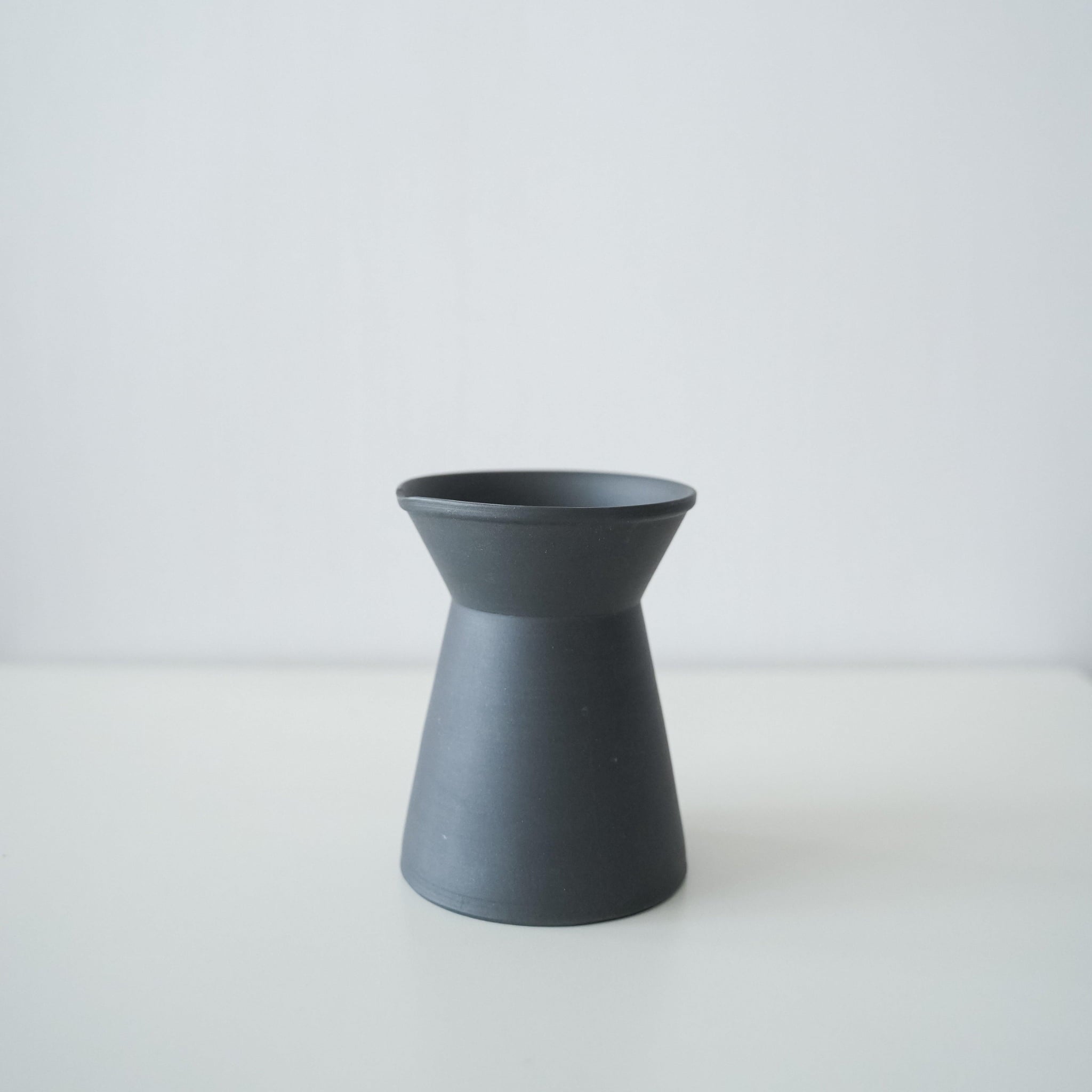 A minimalist black coffee server made of traditional Japanese Banko ware.