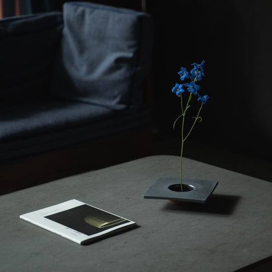 Close-up of a minimalist iron ikebana vase, showcasing the kenzan (flower frog) for arranging flowers.