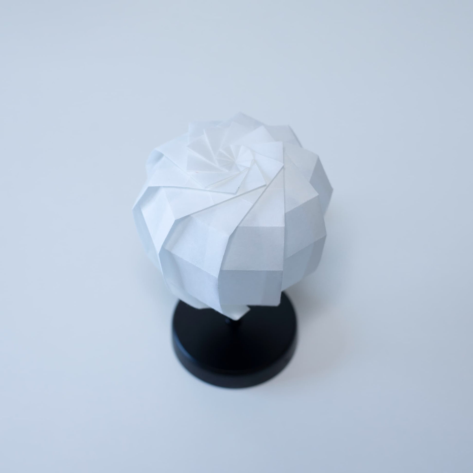 Origami Table lamp "maru" with a black stand and a spherical white lampshade crafted from intricately folded washi paper.