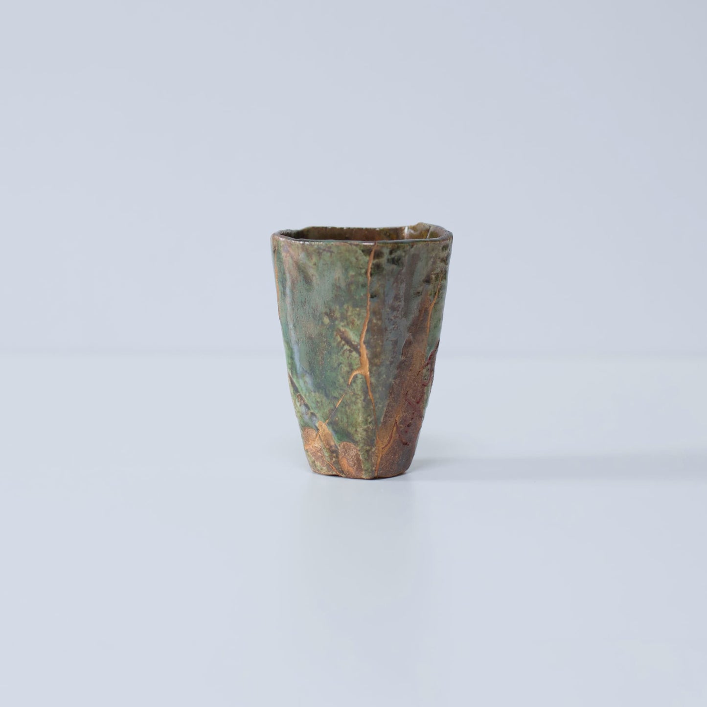 Side view of Pentagon Kintsugi Cup "Oribe" Deep Green 01 against white background