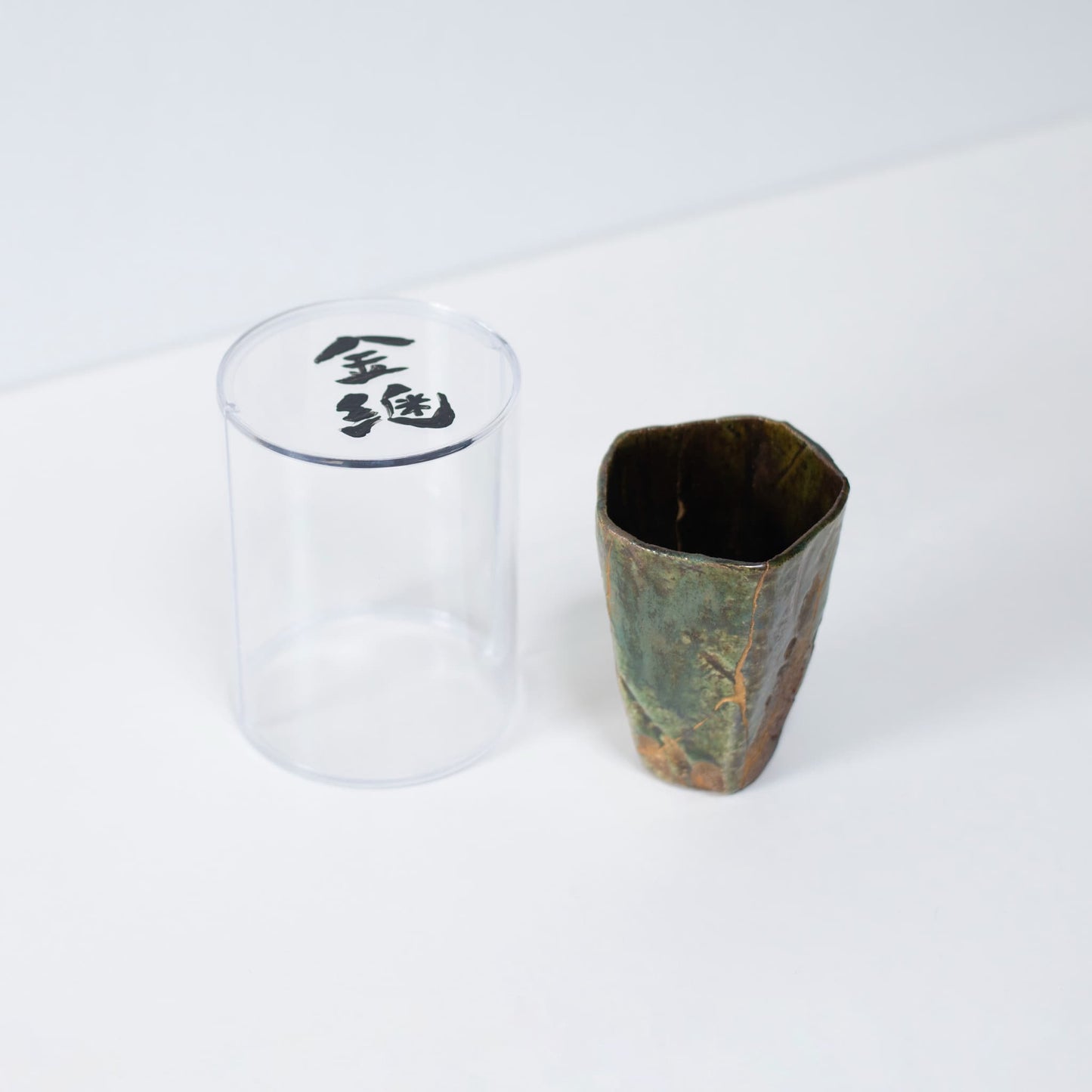 Pentagon Kintsugi Cup "Oribe" Deep Green 01 in clear presentation case, top view