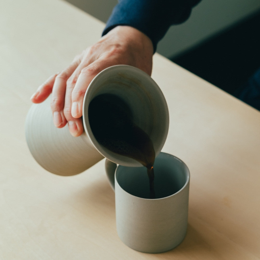 Verser du café d'un serveur en poterie japonaise dans une tasse à café | Service à café de cuisine Japandi