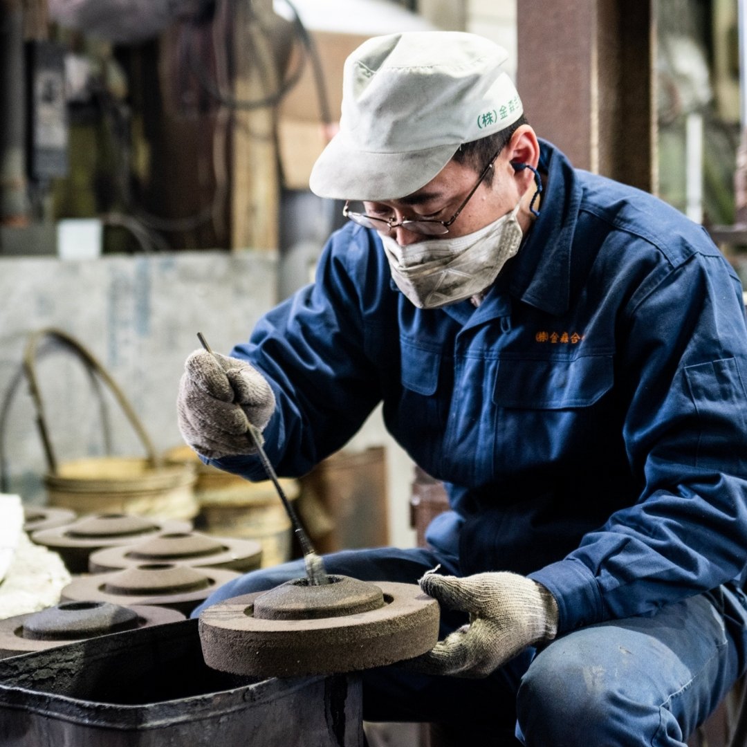 Artisan hand-finishing Kanamori Alloy sand casting for ikebana kenzan and sake cups