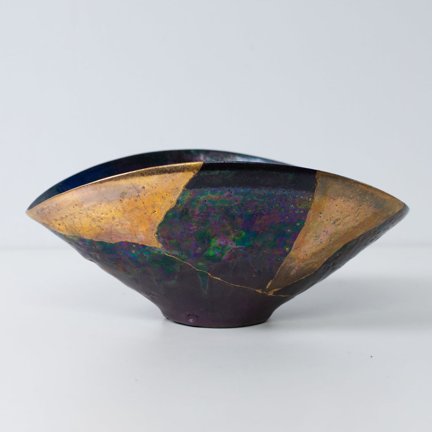 Side view of Kintsugi art bowl showing gold lacquer repairs and elegant wabi-sabi form