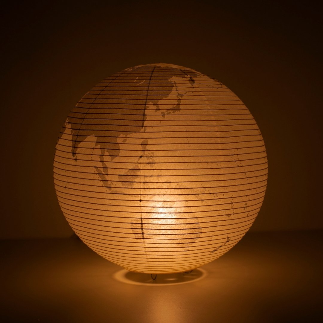 The Japanese Paper Floor Lamp "paper moon 05G" glowing softly, globe-inspired floor lamp