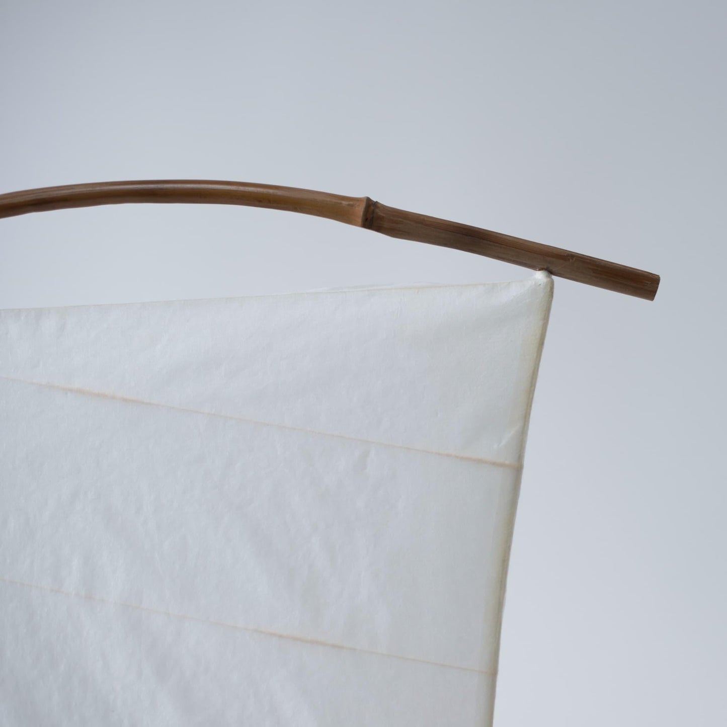 Close-up of the top of Japanese Paper Floor Lamp "NOW" against a white background