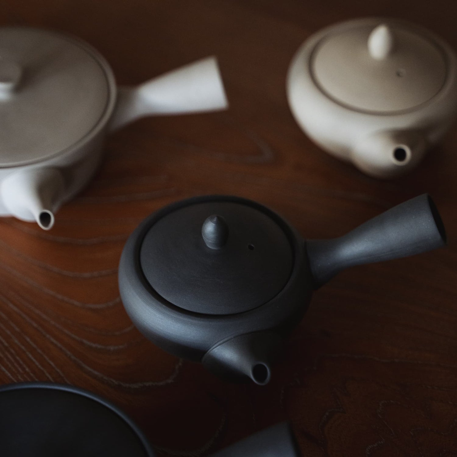 Three Japanese teapots on a wooden table