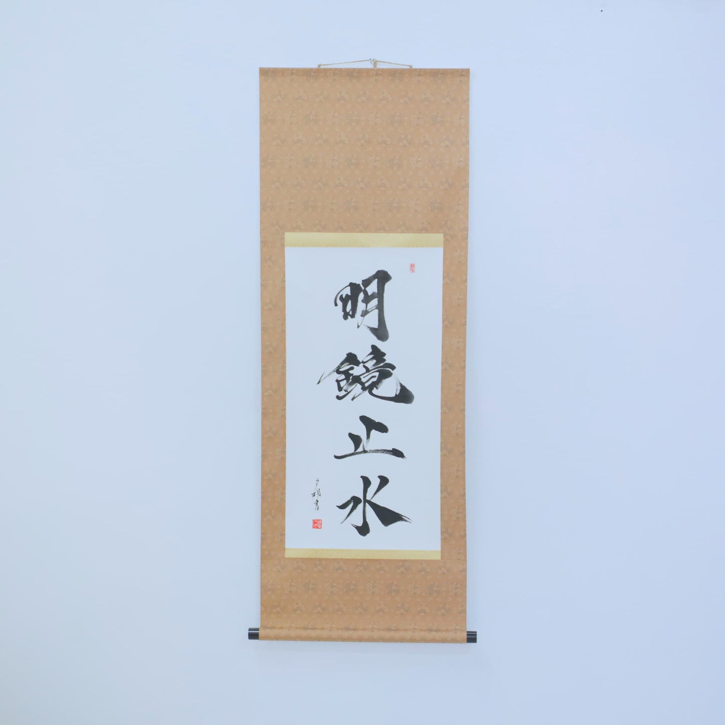 Japanese scroll with Meikyo Shisui calligraphy displayed on white wall