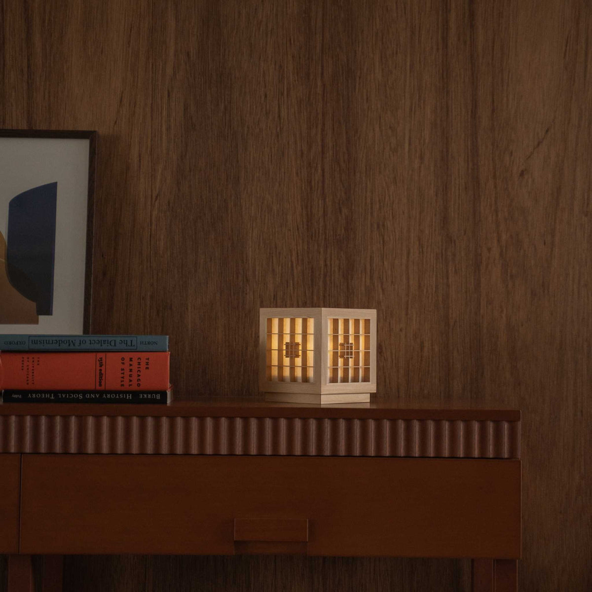 "Lit Japanese Wood Table Lamp \"Honoka\" auf einem Mid-Century-Modern-Konsolentisch, die einen warmen Schein in ein Mid-Century-Modern-Wohnzimmer wirft."