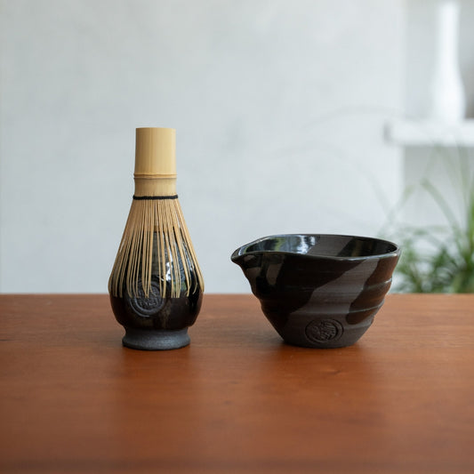 Sumi Black spouted matcha bowl and Japanese matcha whisk stand on a wooden table for an authentic matcha whisking ritual