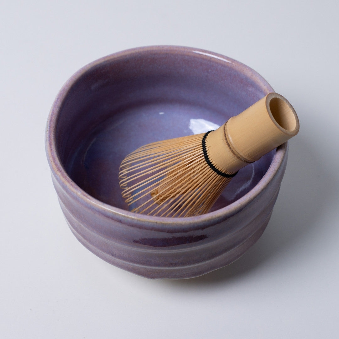 Top-down view of the "Pale Violet" matcha bowl with a tea whisk, showcasing the sophisticated purple hue for modern interiors.