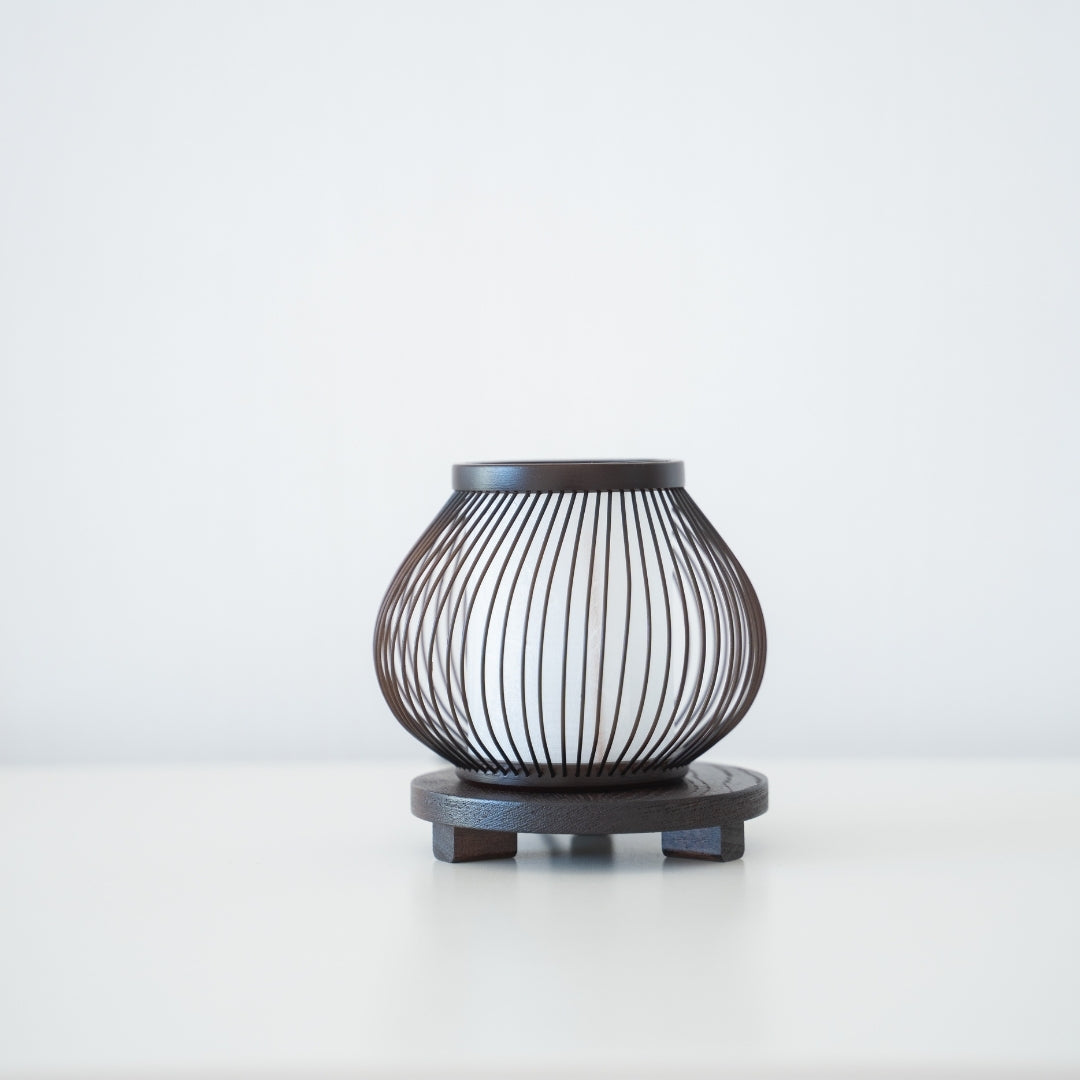 Lampe de table minimaliste en bambou sur une table dans une chambre de style Japandi, mettant en valeur 800 ans de savoir-faire de Shizuoka, Japon.