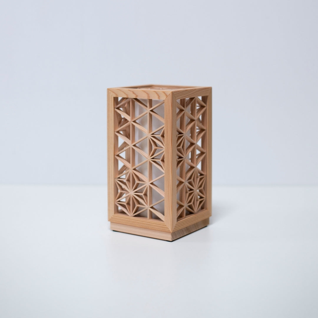 Une lampe de table utilisant le kumiko, une technique japonaise traditionnelle d'assemblage de petites pièces de bois pour créer des motifs géométriques.
