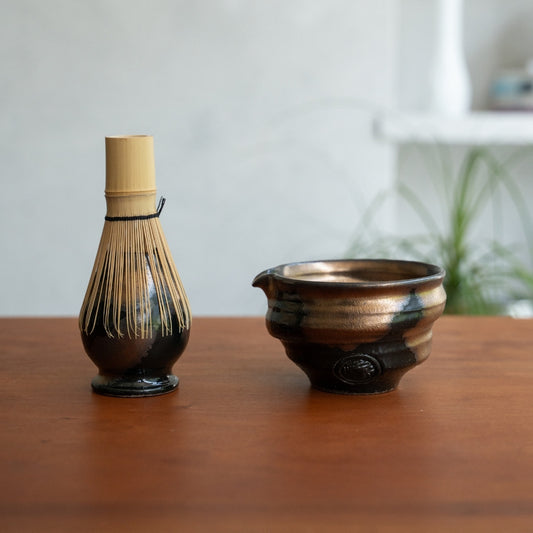 Japanese matcha whisk stand and matcha bowl with spout on a wood table, keeping tools ready for a daily wellness routine.