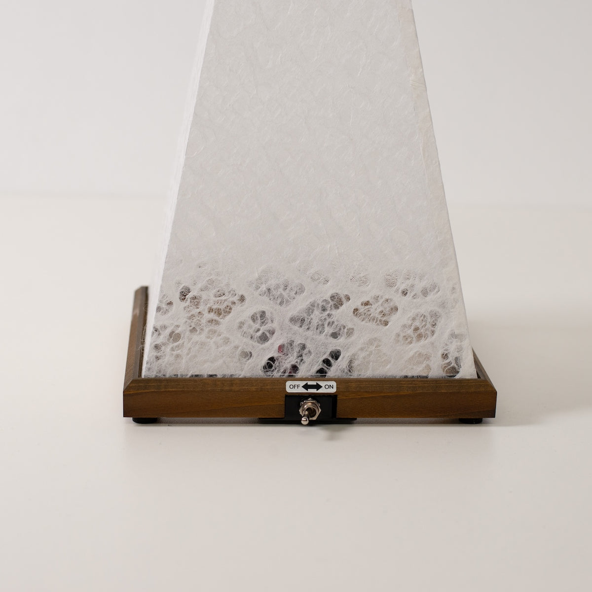 Japanese Paper Table Lamp "Mini Akari", white, wood - close-up of wooden base and toggle switch for the cordless lamp.