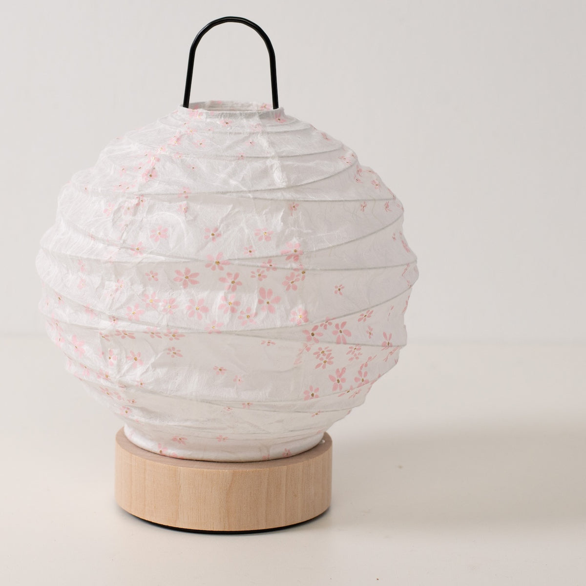Japanse Papieren Tafellamp "Yuhi" Sakura, wit, Mino Washi papier en hout - schuine weergave van onverlichte ronde papieren lamp en massief onderstel.