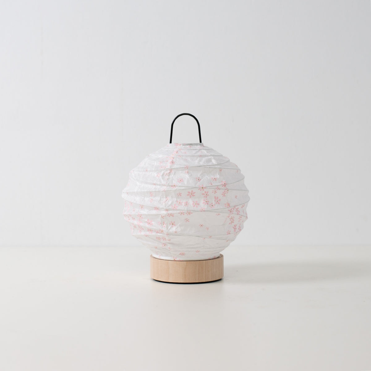Japanse papieren tafellamp "Yuhi" Sakura, wit, Mino Washi papier en hout - onverlichte ronde accentlamp uit Japan op een wit oppervlak.