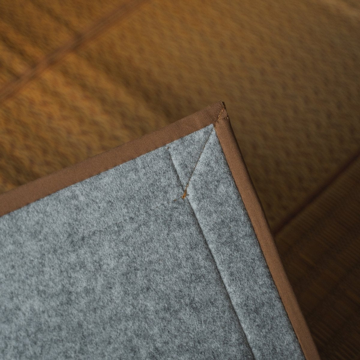 Japanese natural beige rush tatami area rug showing its non-woven backing, providing a floor-safe base for modern rooms.