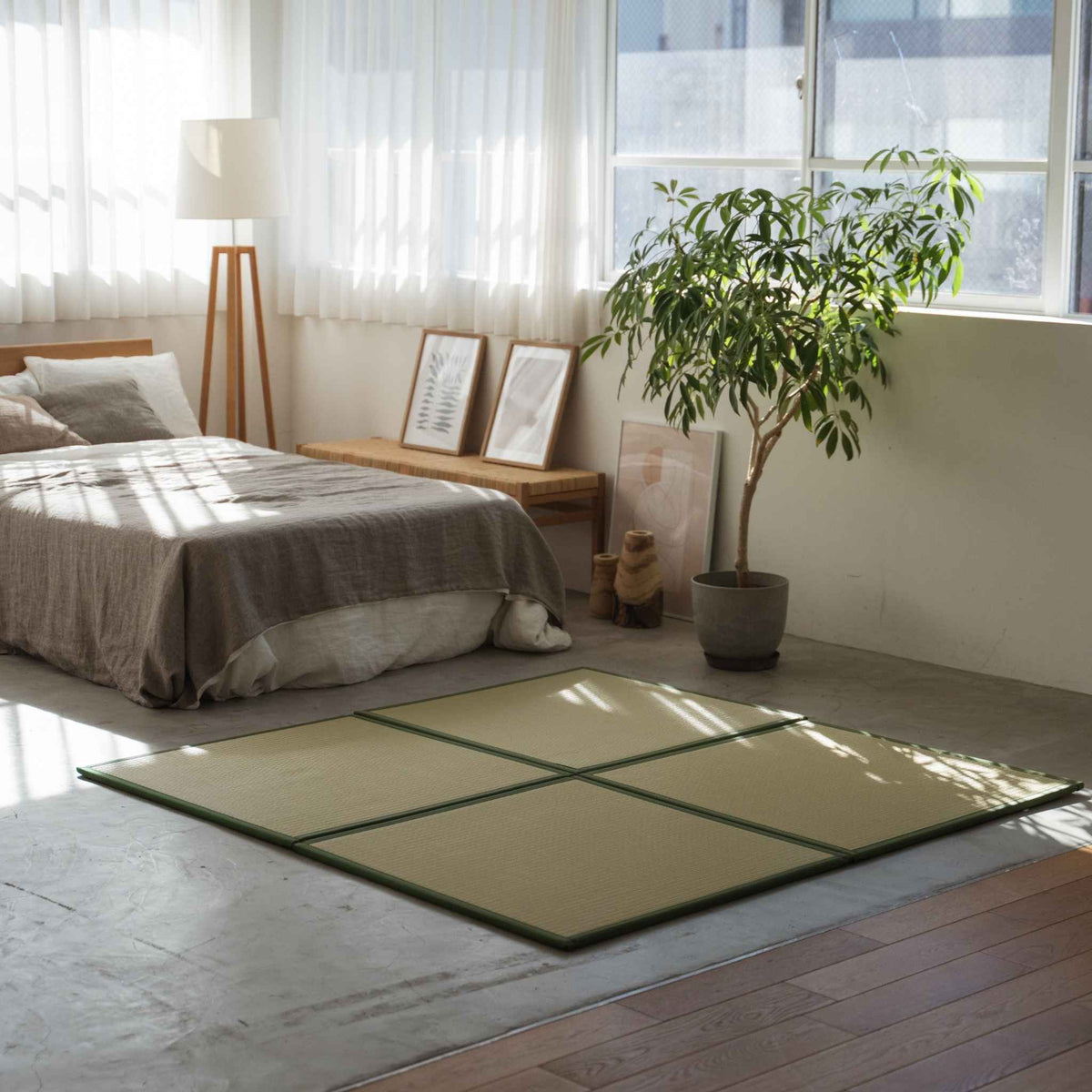Green square tatami mats arranged on a concrete bedroom floor creating a stylish and stain-proof meditation corner.