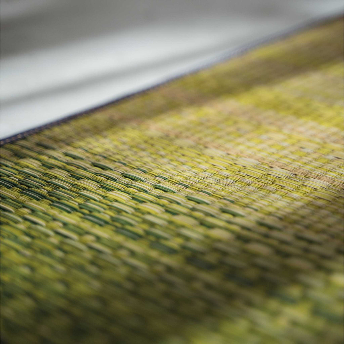 Close up of the woven rush grass texture on a green tatami mat showing its breathable natural surface.