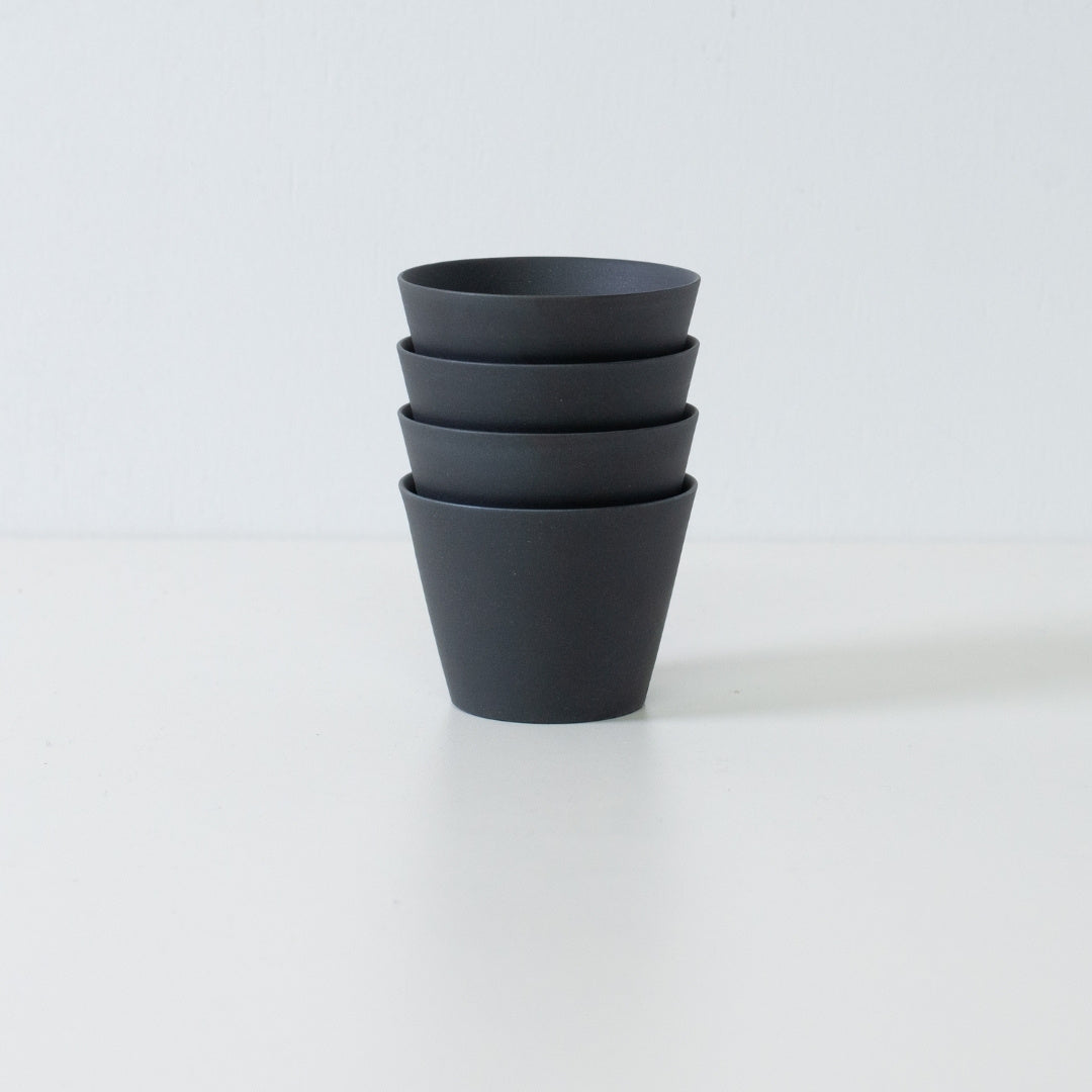 Stack of four black ensui japanese tea cups displaying the space saving design of this modern stoneware set