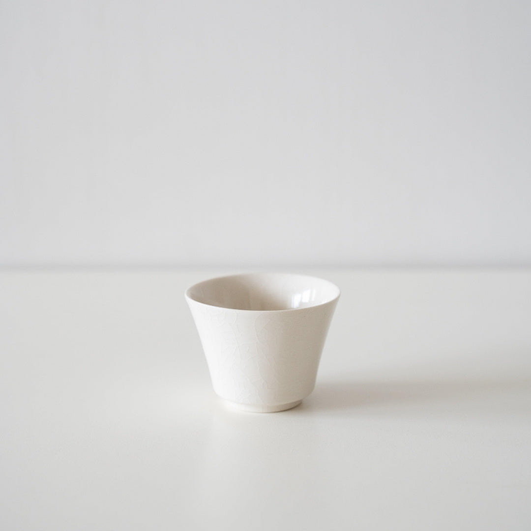 "Witte Kodai Japanse theekop met craqueléglazuur, gecentreerd op een minimalistische achtergrond voor een verfijnde theeceremonie-ervaring."