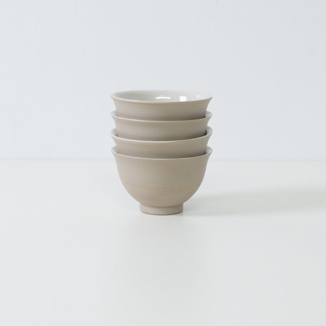 Stack of four beige kumidashi Japanese tea cups displaying their storage efficiency.