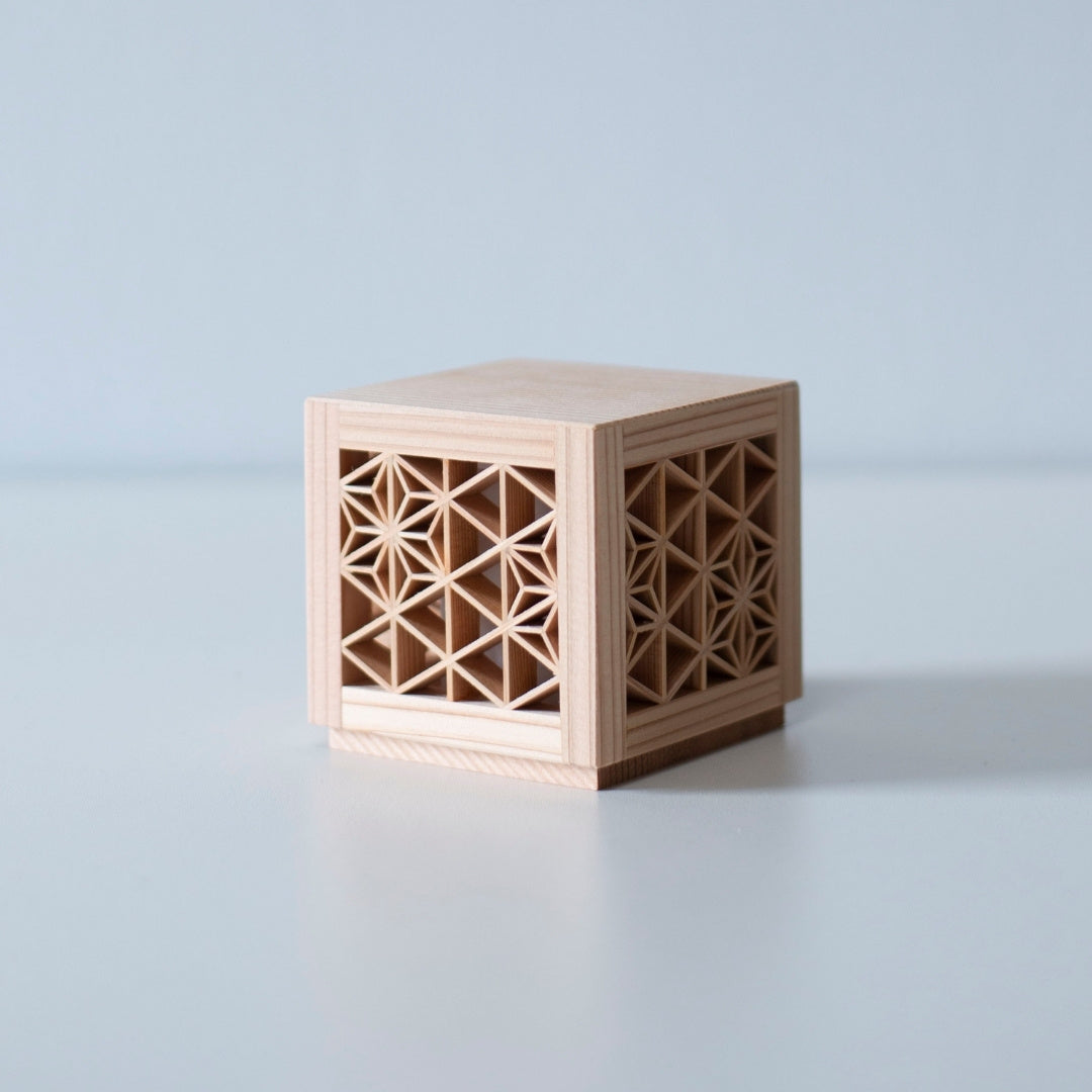 An unlit kumiko light fixture, revealing the intricate wooden latticework and the natural grain of the wood.