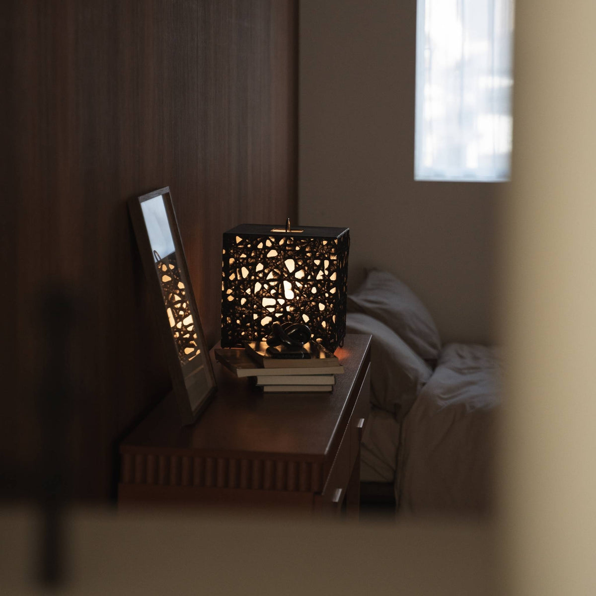 Illuminated cube Japanese paper lamp Me Look 03 acting as an accent light on a wooden console table with decor.