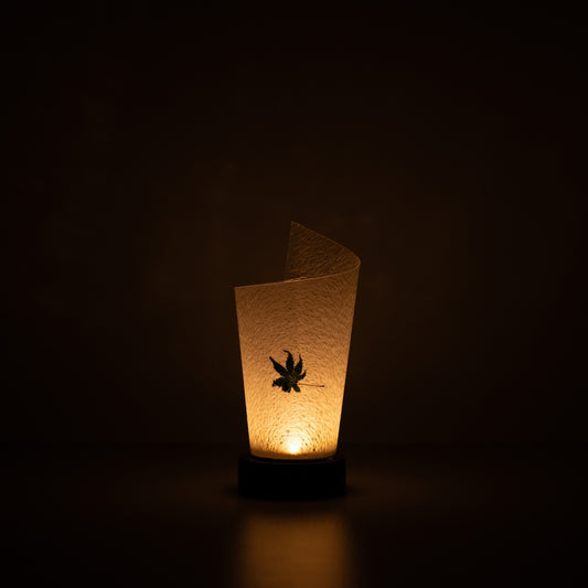 Japanese Paper Table Lamp "Maki" Momiji Leaf, white, Mino Washi paper - lit paper lamp casting a warm glow with visible rustic flecks.