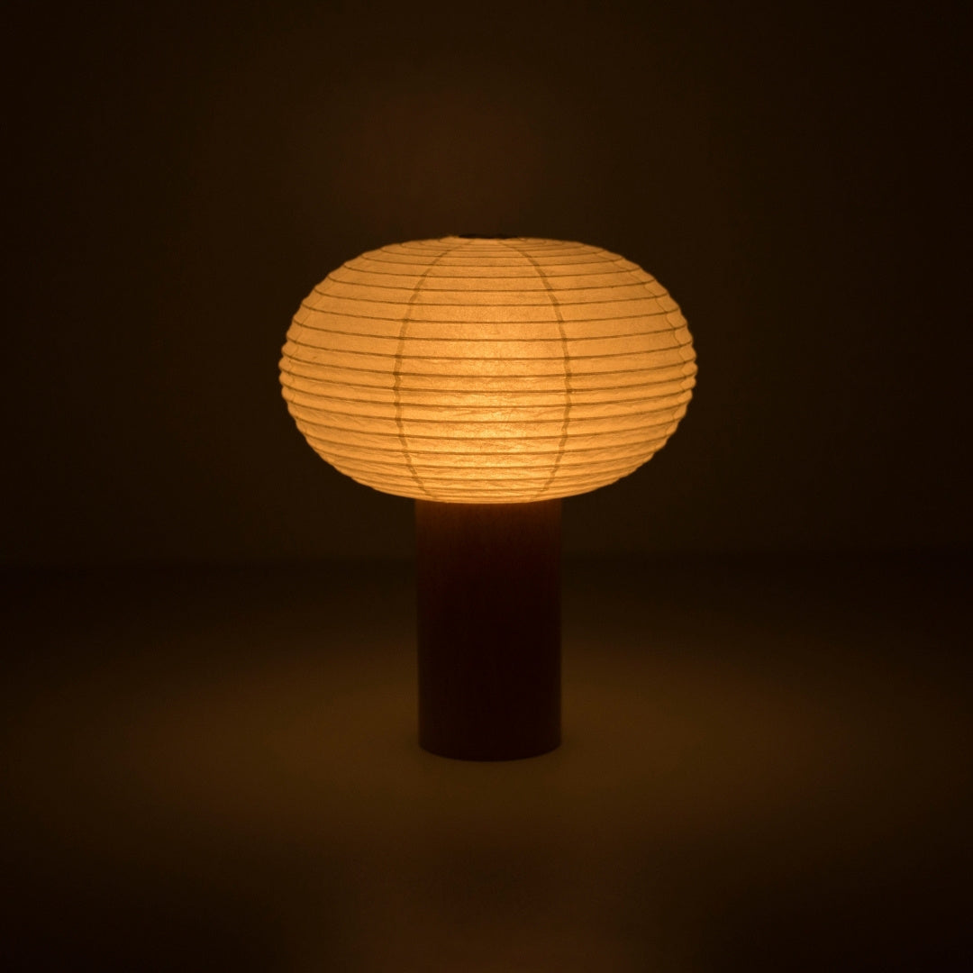 Portable paper lamp "TORCHIN OVAL" emitting a warm glow, handcrafted in Yame, Fukuoka, Japan, known for its traditional Yame lanterns.