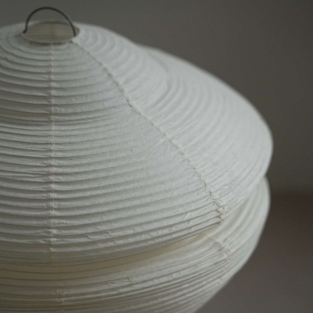 Close up detail showing the translucent texture and ribbed design of the Harusame Mino Washi paper on the Gemini 01 lamp shade.