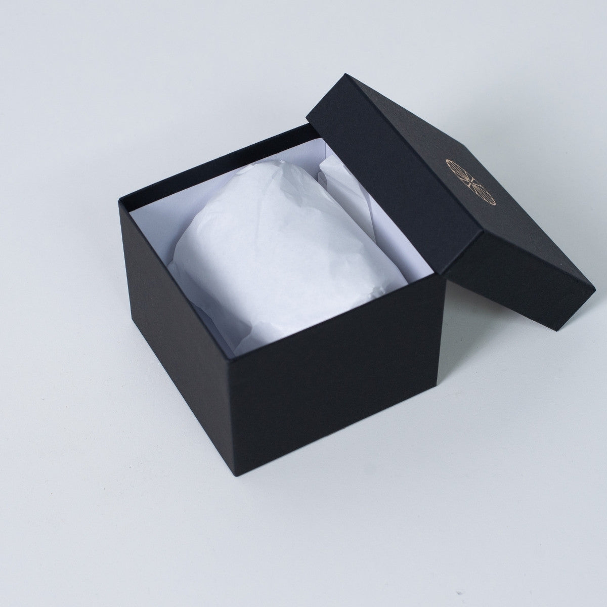 Open black square Ninshu's gift box for Japanese incense burner pottery, with a wrapped ceramic vessel visible inside white packaging.