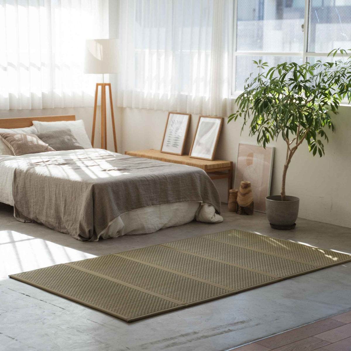 Semi-dubbele tatami matras op de vloer in een zonnige kamer, dient als vochtregulerende basis voor een futon.