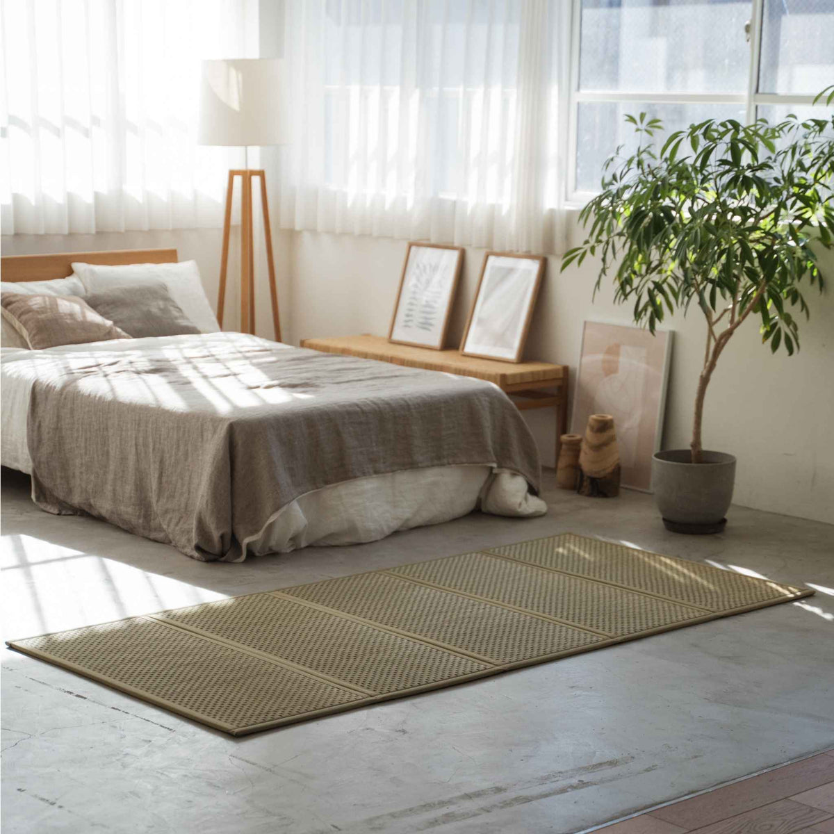 Enkele groene tatami matras gelegd op een betonnen slaapkamervloer, wat een ademende basis biedt voor zen-decor.