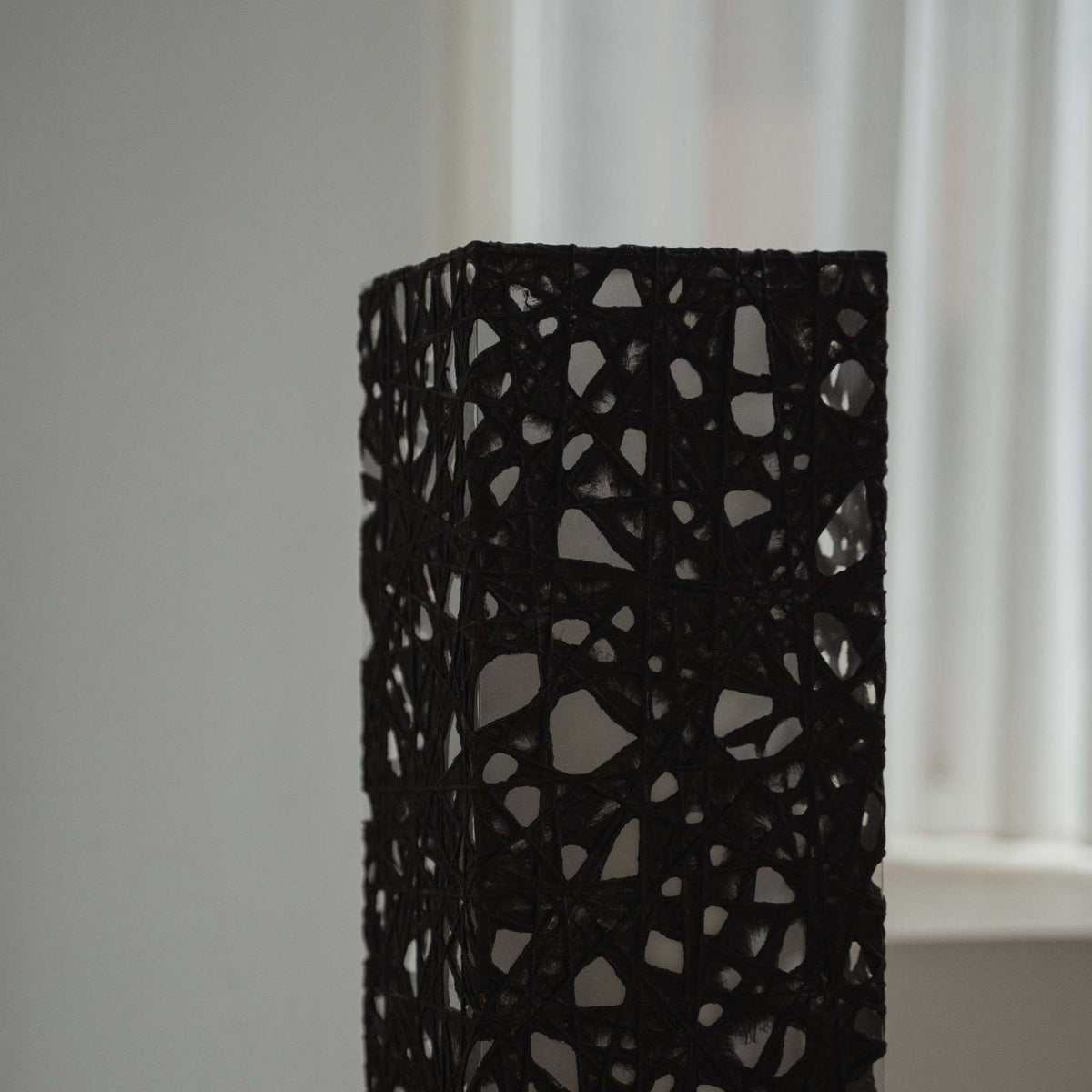 Tæt på detalje af den sorte Melook papirtekstur med spindelvævslignende Kozo-fibre på Me Look 01 lampeskærmen.