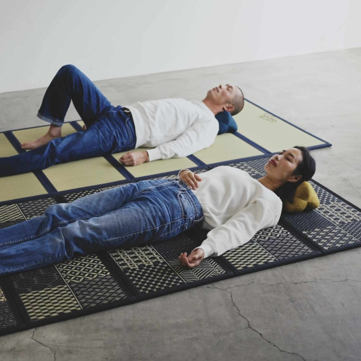 Couple sleeping on breathable five panel tatami mattresses on a floor enjoying deep rest.