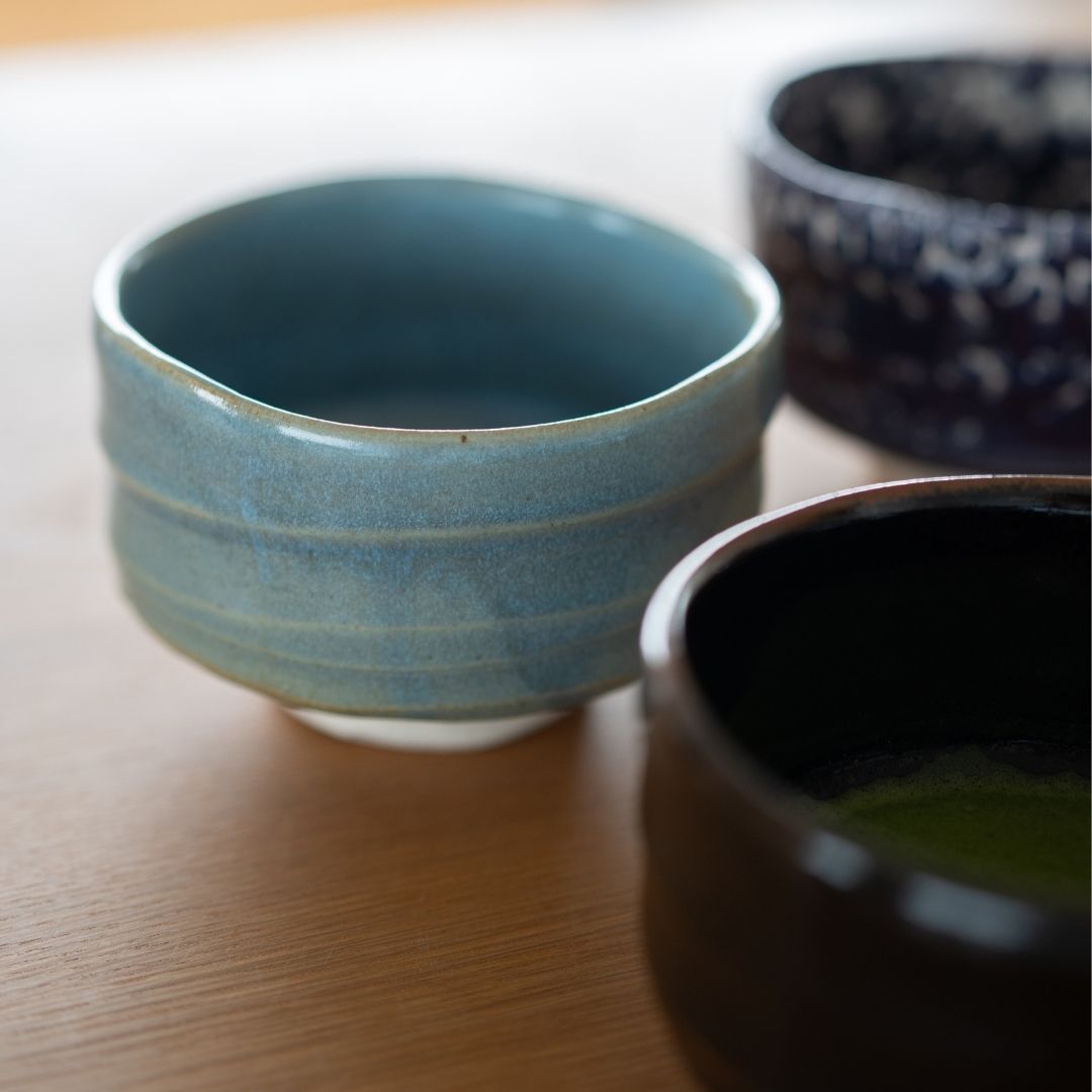 Close-up of three Wabi Sabi Japanese matcha chawan bowls by Shinzan Kiln, featuring Summer Sky blue and Yuzu Black.