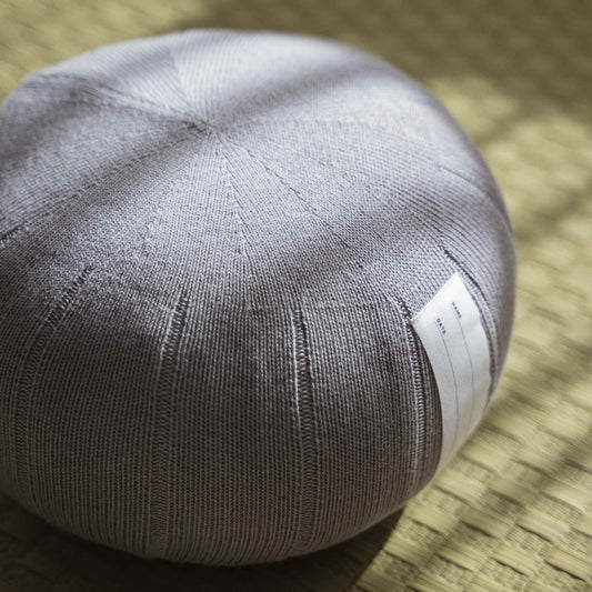 Lagoon gray zafu meditation cushion handcrafted from organic cotton placed on a traditional tatami mat.