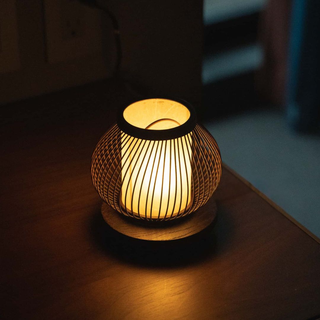 A Japanese bamboo table lamp casts a warm light on a table