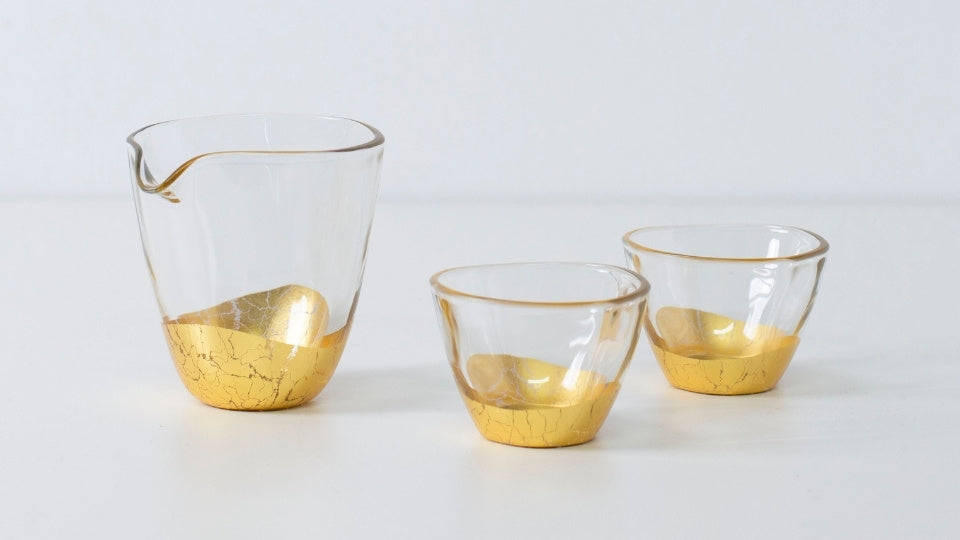Elegant Japanese sake set with gold leaf design, including sake bottle and two cups in crackled finish