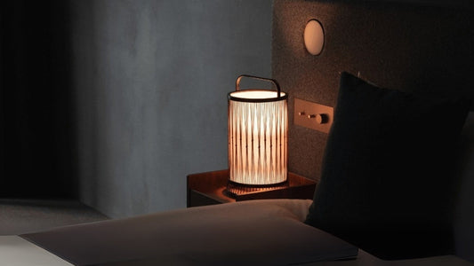 A Japanese bamboo lamp placed on a bedside table in a Japandi-style bedroom.