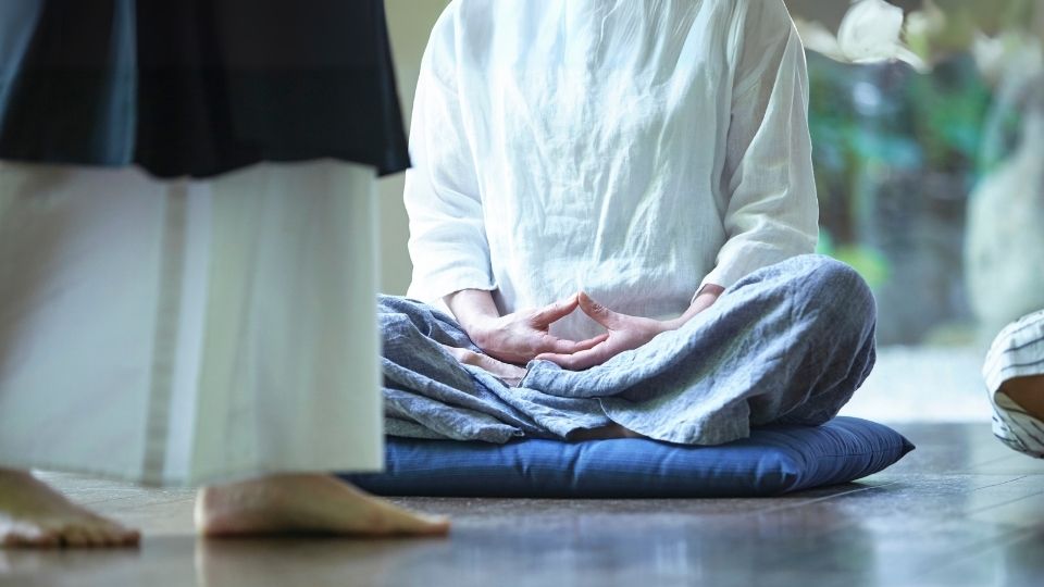Practicing traditional zazen on a meditation cushion during a calm mindfulness session indoors