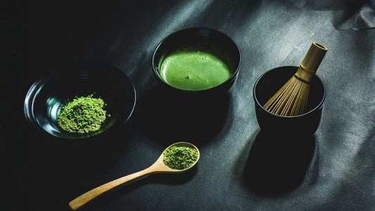 Thé vert glacé rafraîchissant servi dans un bol à matcha transparent avec des glaçons, illustrant un style d'été de matcha.