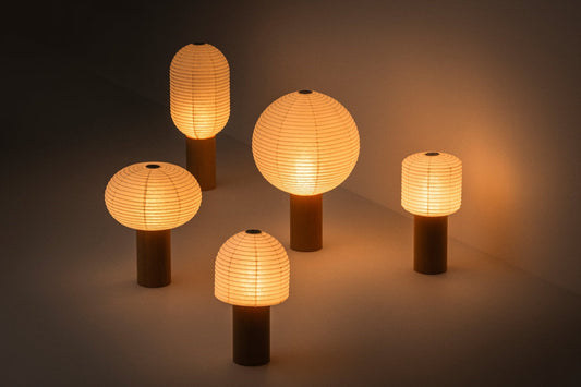 "Japanse papieren lamp uit de 'TORCHIN'-serie straalt een warme gloed uit in een schemerige kamer"