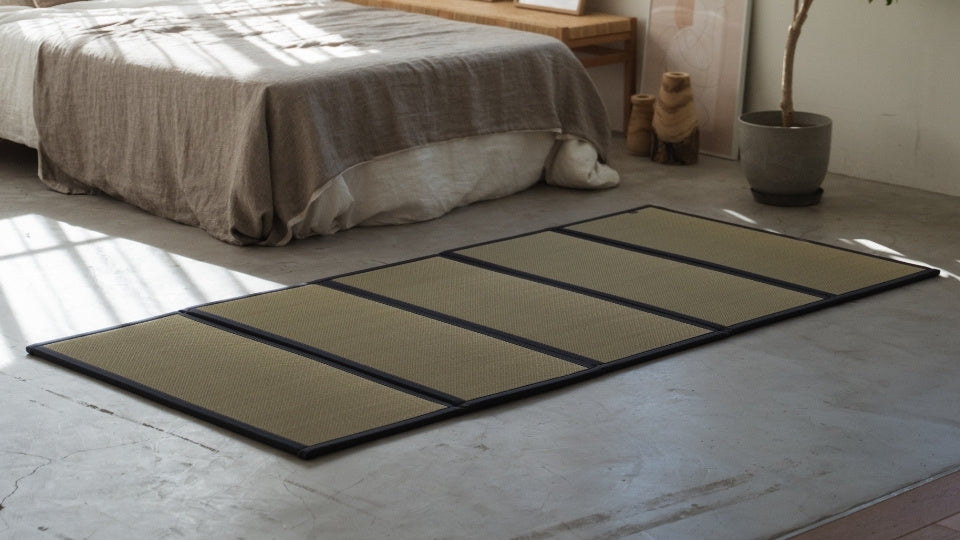 Five panel tatami mattress on a concrete bedroom floor serving as a breathable and healthy base for a futon.